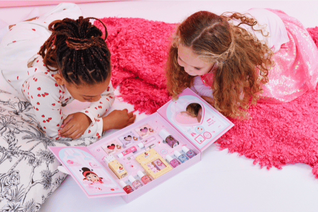 Mutter lackiert ihrer Tochter die Fingernägel mit rosa Miss Nella Kindernagellack