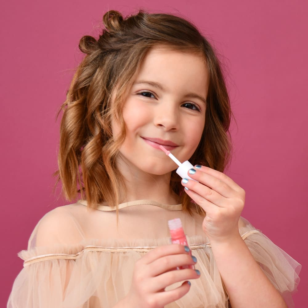 mädchen trägt sanft lipgloss auf